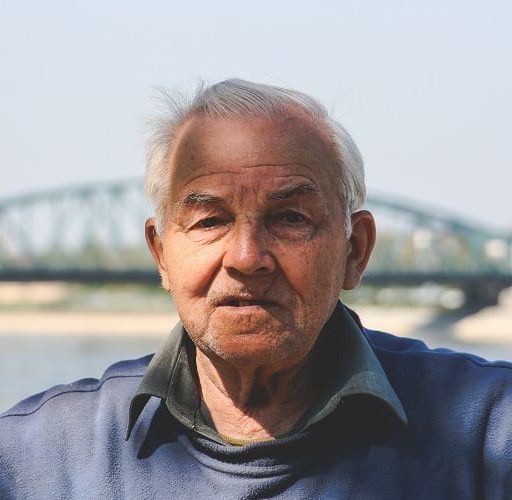 old man with bridge in background