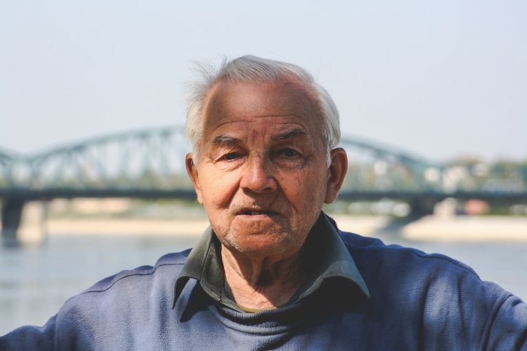 old man with bridge in background