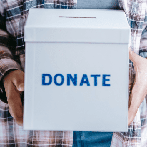 Person holding a box labeled Donate.