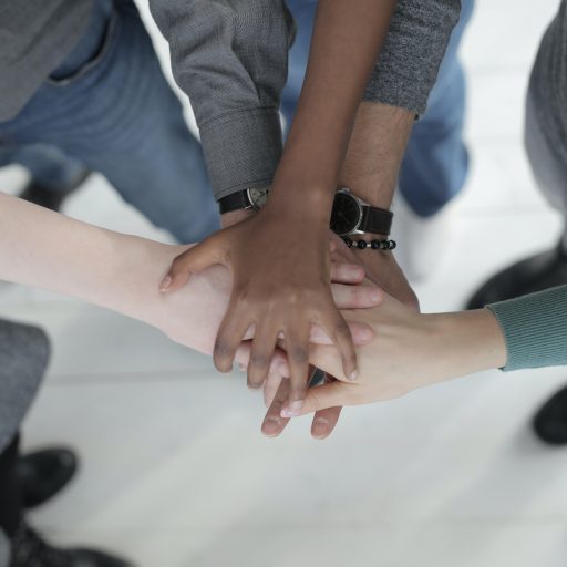 Group of people piling hands in the middle of them